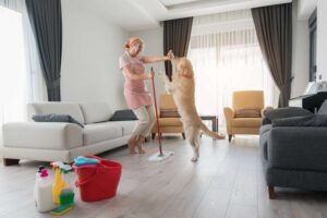 woman mopping floor with dog