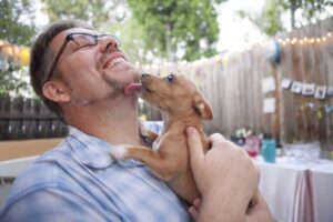Man getting licked by a puppy